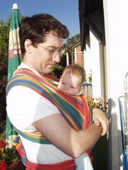 A father wearing his 4 month old infant in a sling